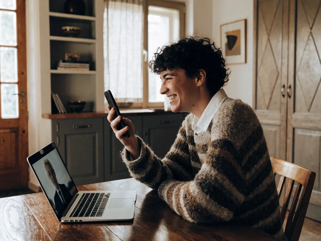 Patient at home photographing their own smile during an online video consultation with a clinician