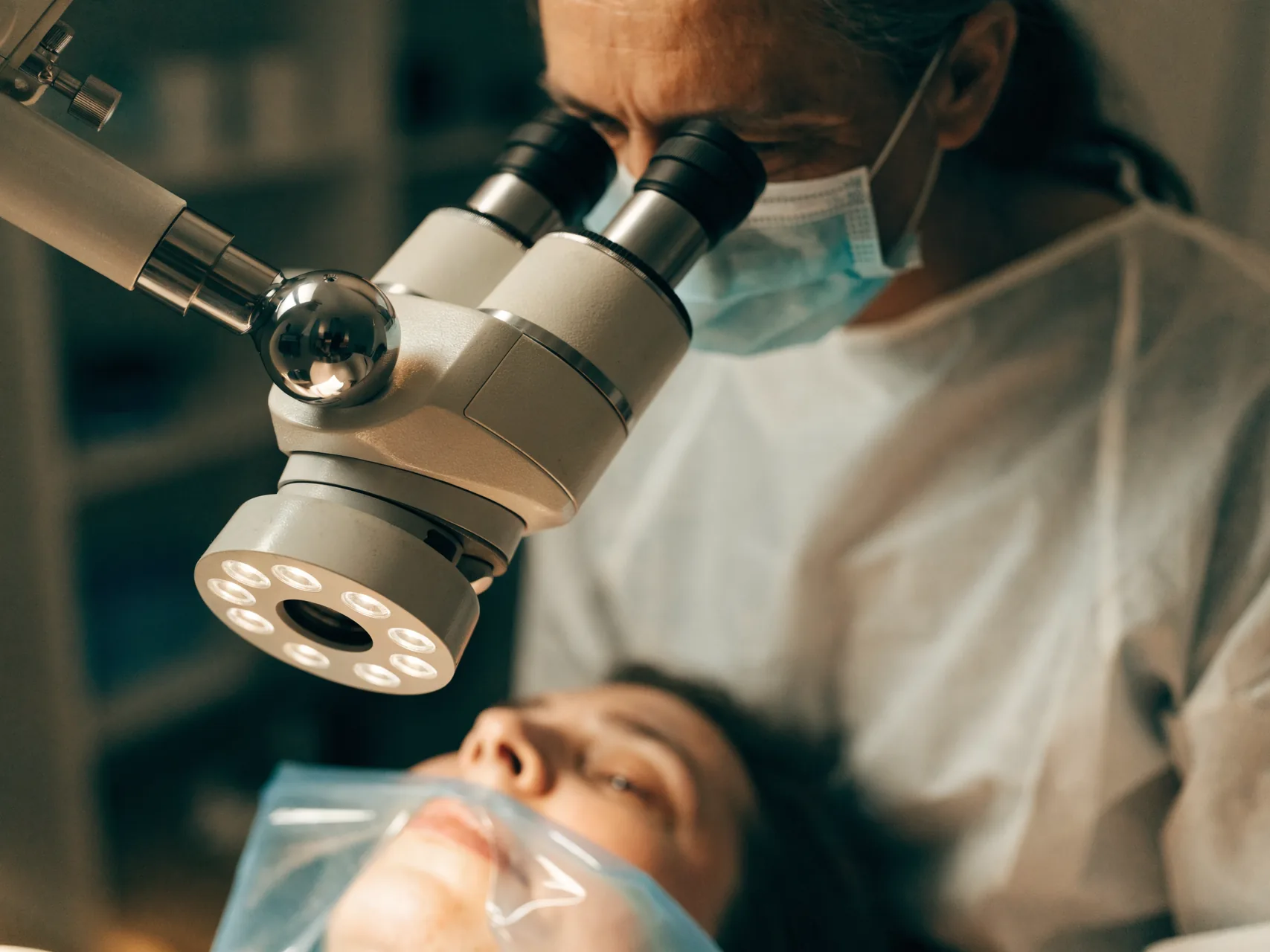 Endodontist working through a surgical operating microscope during root canal treatment