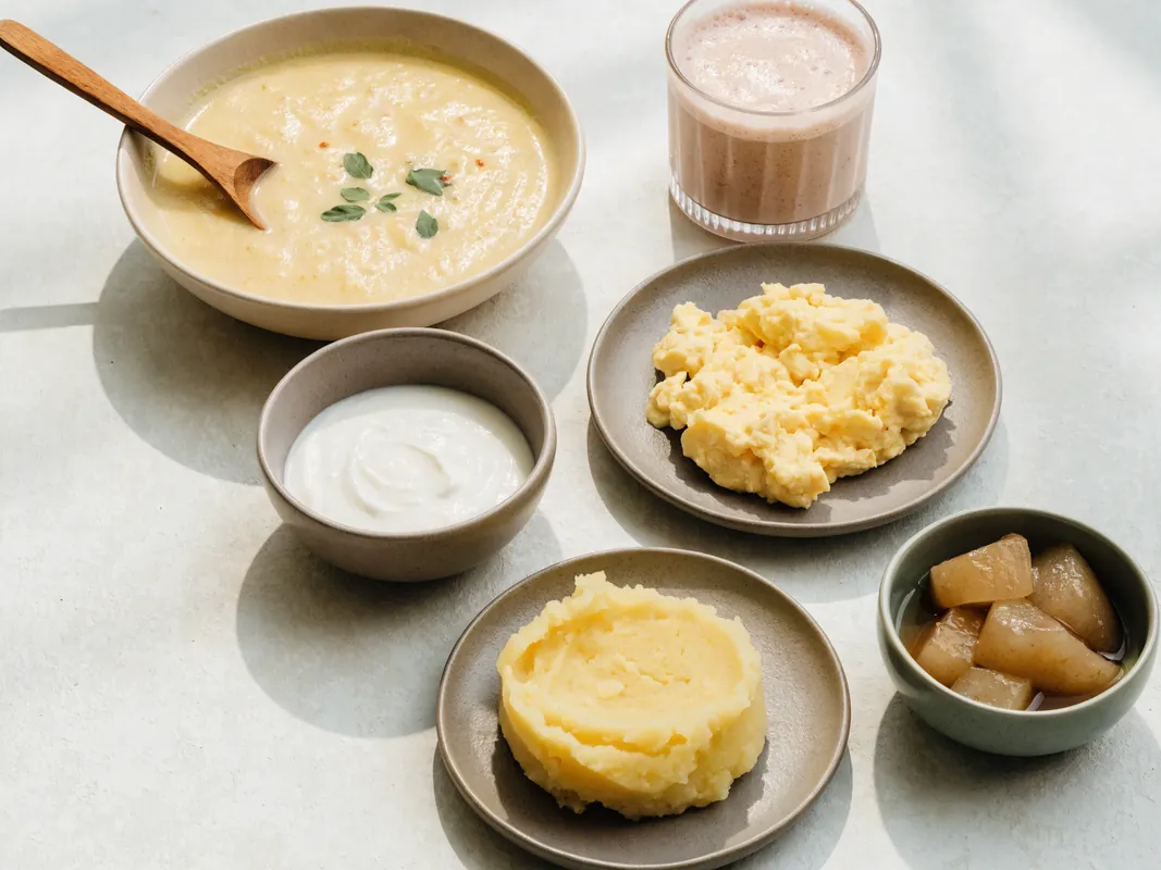 Soft foods suitable for the first days after dental surgery: soup, yoghurt, mashed potato and a smoothie